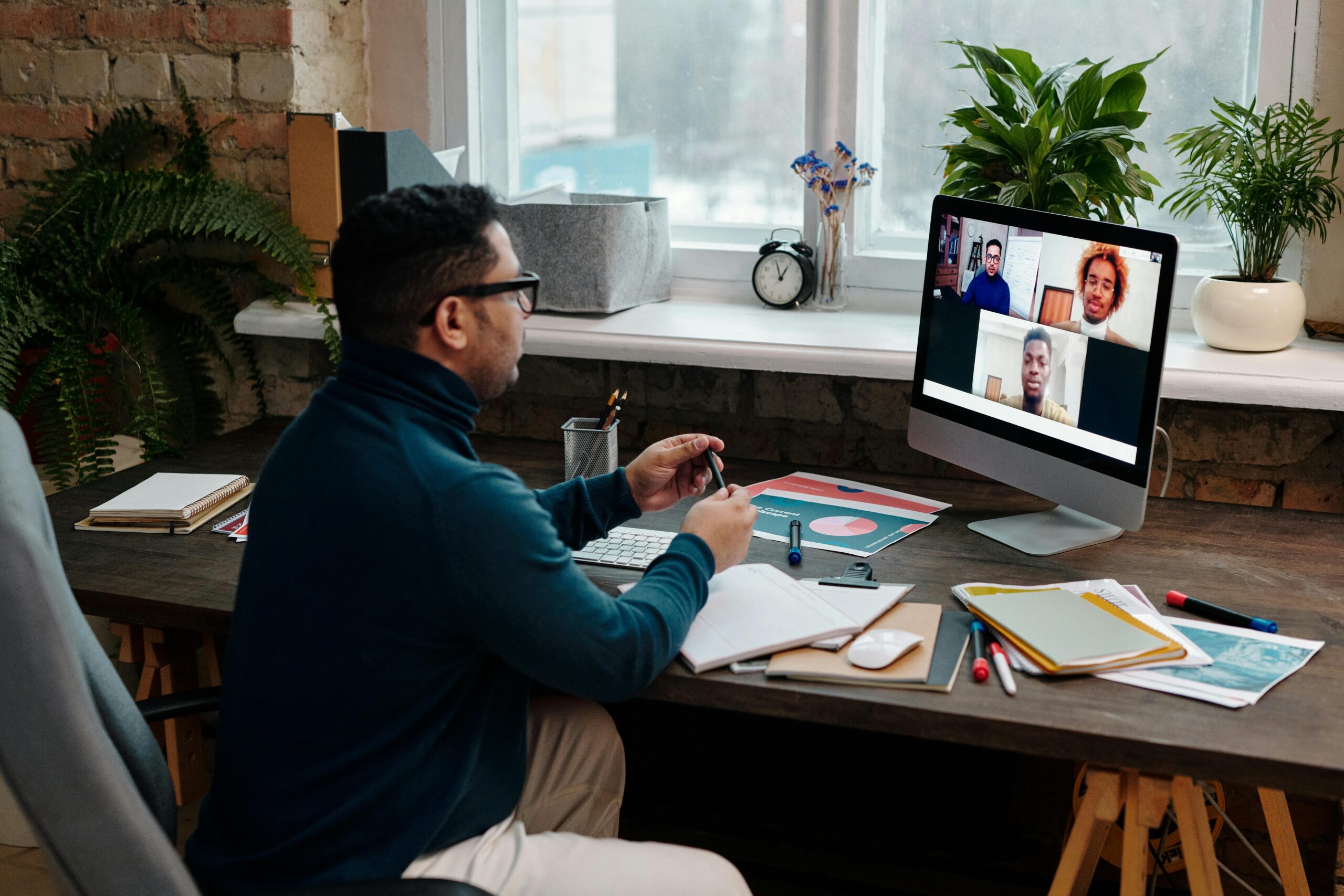 Man engaging in an online meeting from home office, showcasing remote work dynamics.